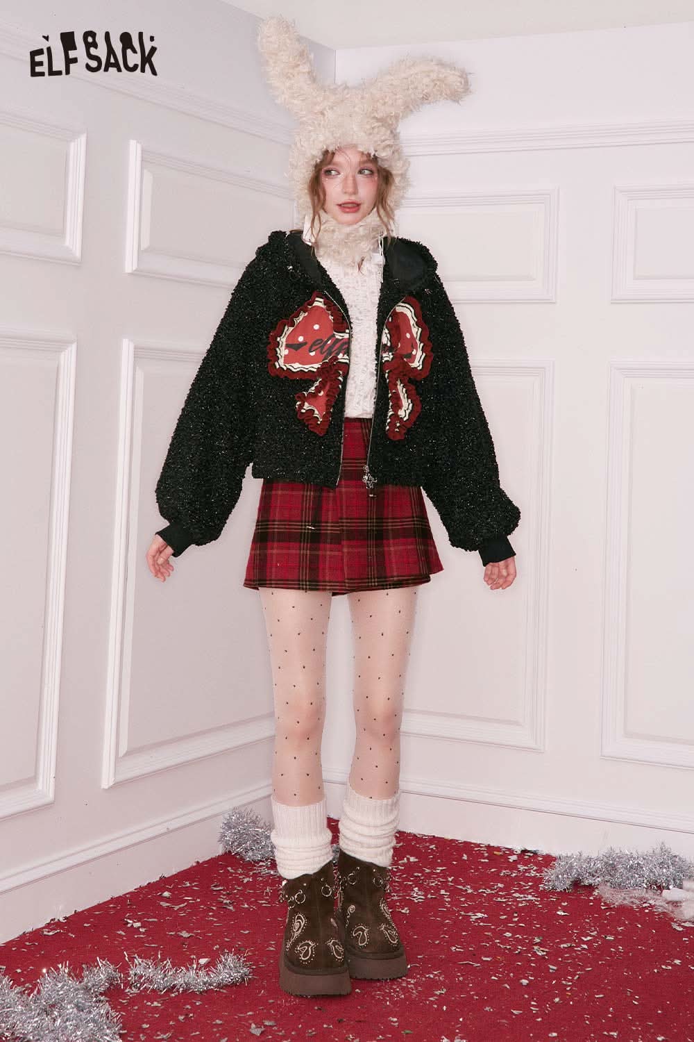 ELFSACK 3D bow glitter plush jacket in black, styled with a plaid skirt and winter accessories