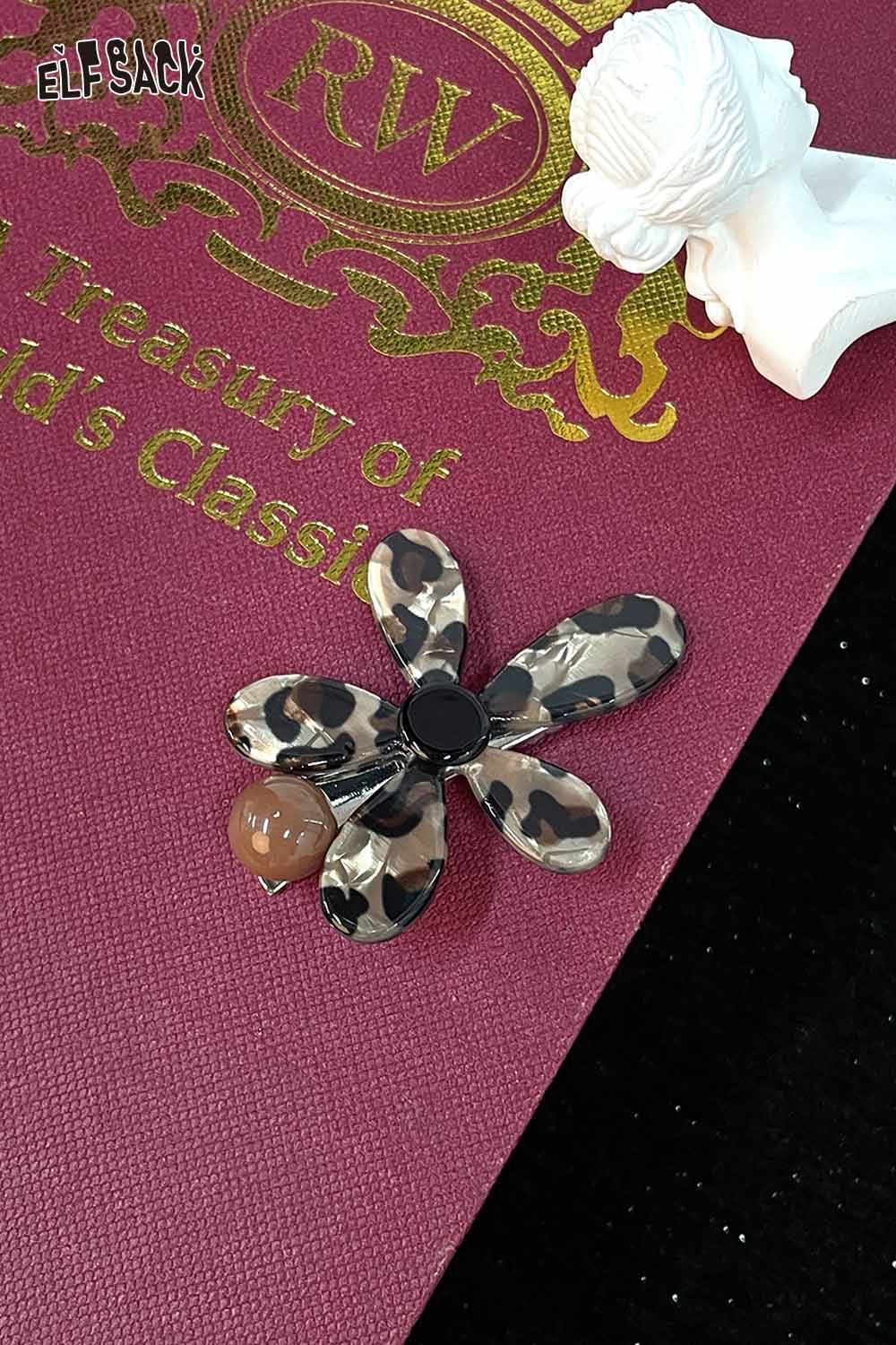 ELFSACK asymmetric floral hairpin featuring a leopard print design with an acorn detail