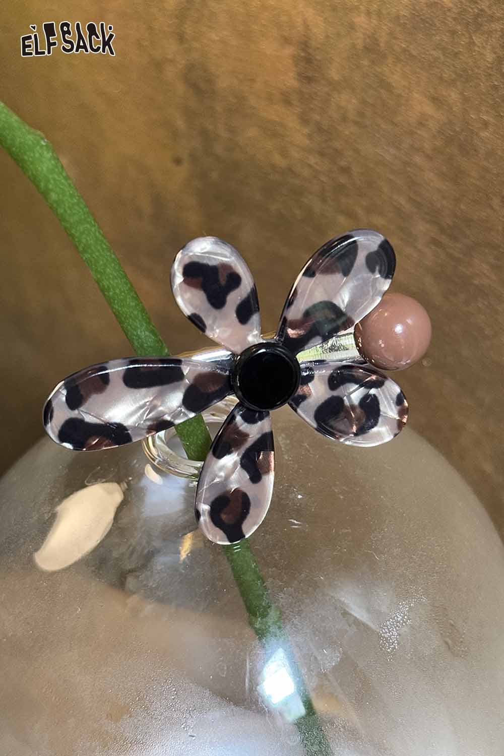 Asymmetric floral hairpin by ELFSACK featuring a leopard print design and a contrasting bead