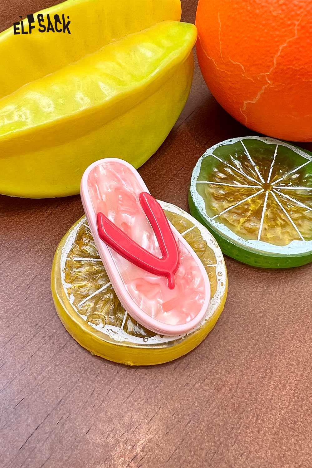 ELFSACK korean cute hair clip pink flip flop sandal shaped clip with red straps displayed on citrus fruit props