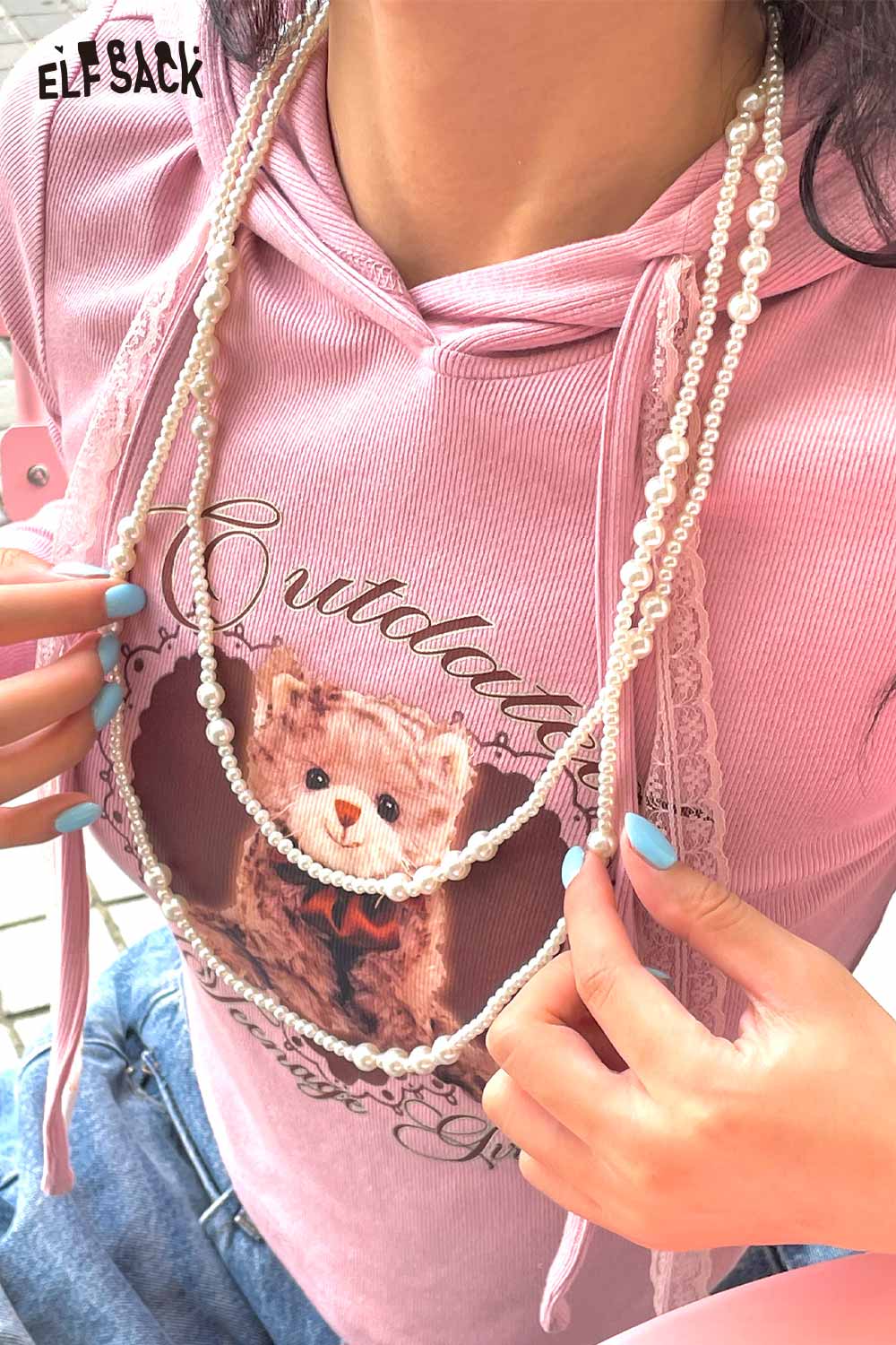 ELFSACK baroque pearl cluster necklace layered over a pink graphic hoodie for a stylish look