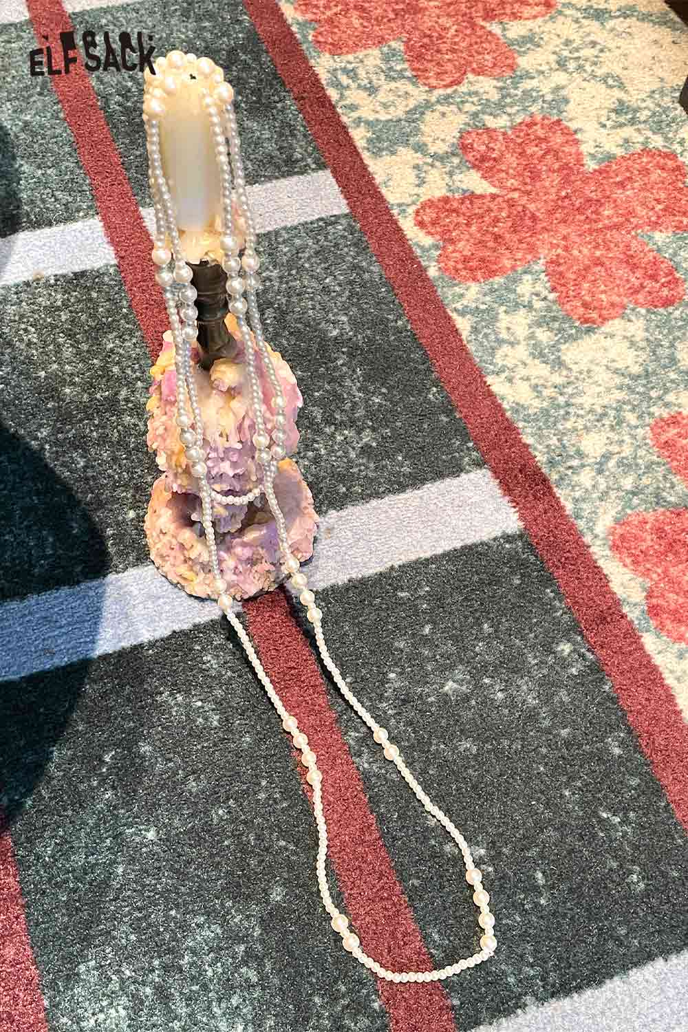 ELFSACK baroque pearl cluster necklace displayed elegantly on a decorative stand