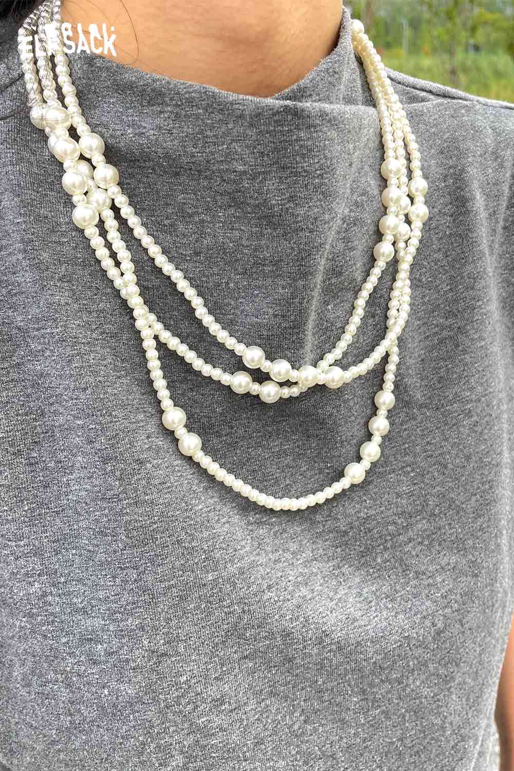 Elegant ELFSACK baroque pearl cluster necklace layered on a gray top for a chic look