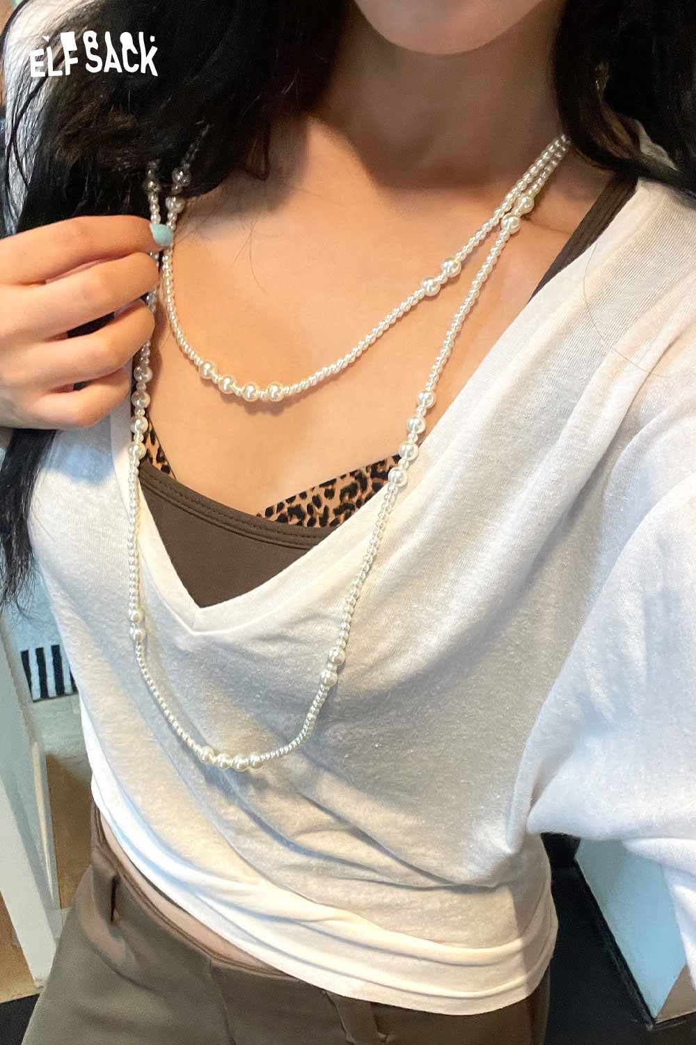 ELFSACK baroque pearl cluster necklace layered over a casual white top and brown tank top