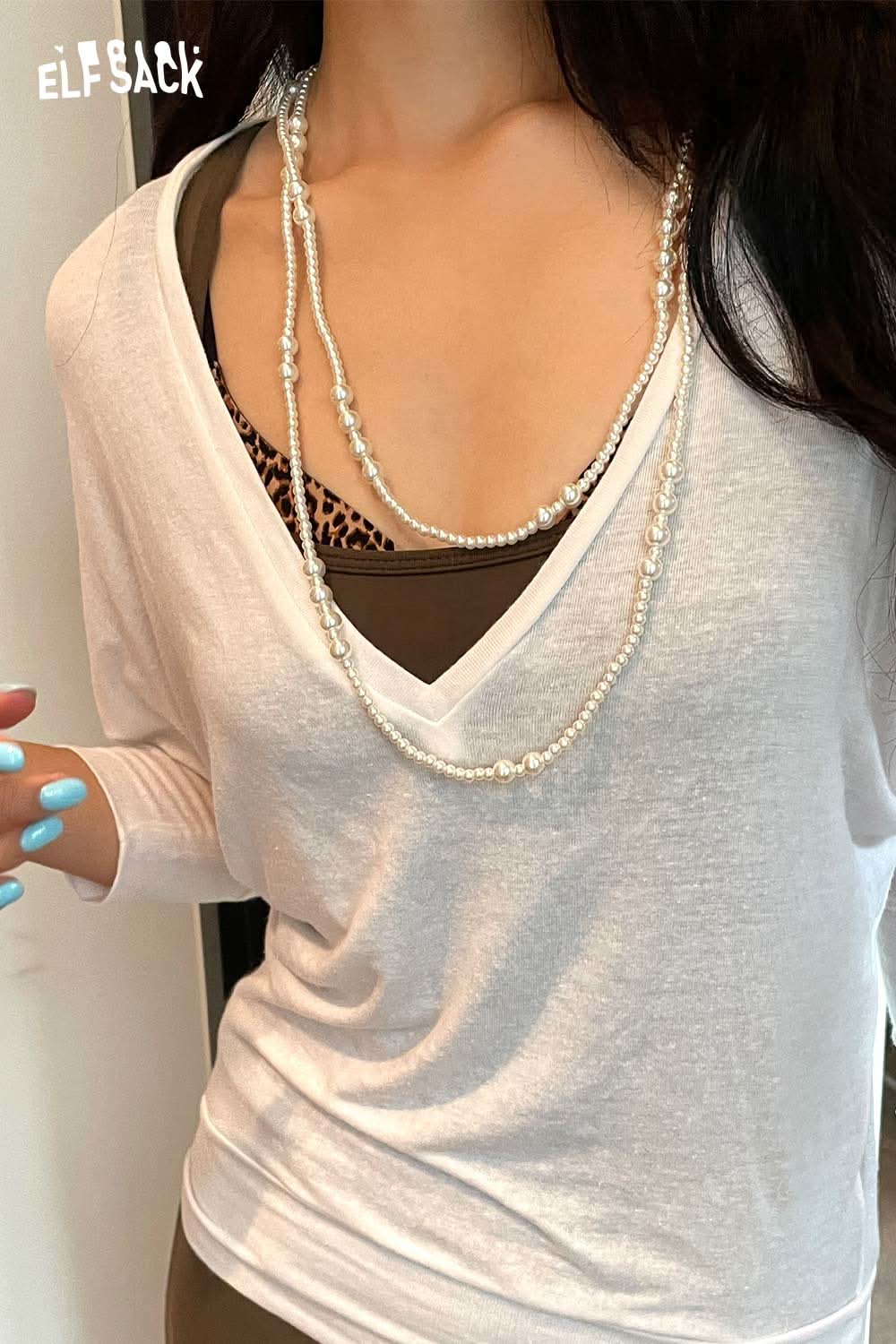 ELFSACK Baroque pearl cluster necklace layered over a white top for a chic look