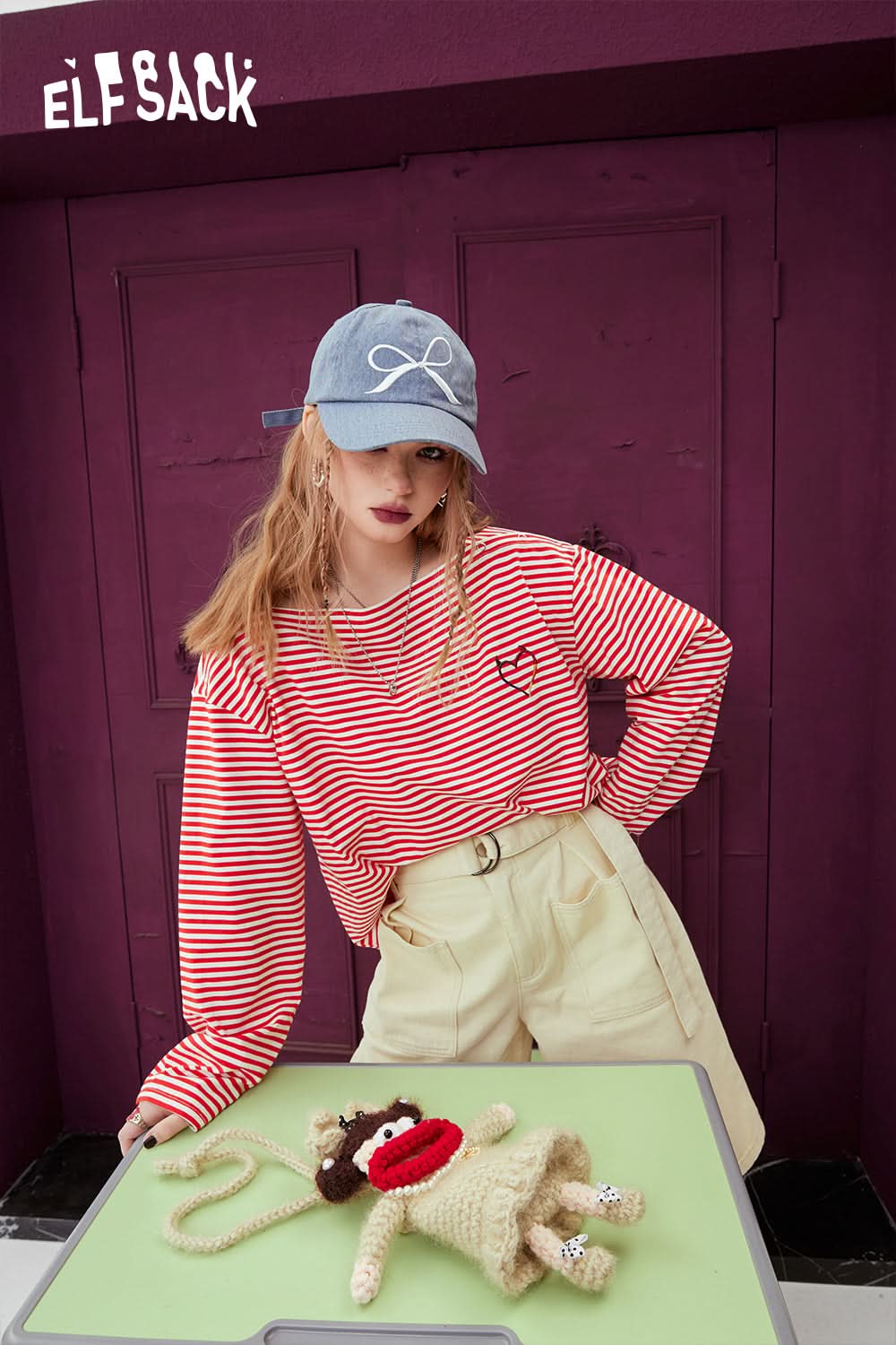 ELFSACK Black & White Striped casual t-shirt worn by model with beige pants and blue cap