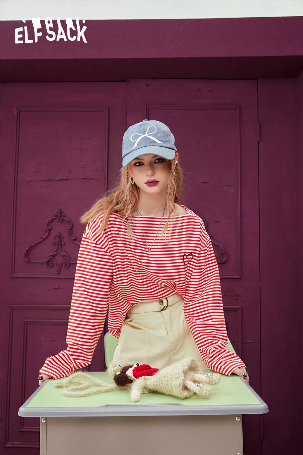 ELFSACK Black & White Striped long sleeve T-shirt worn by model with beige pants and blue cap