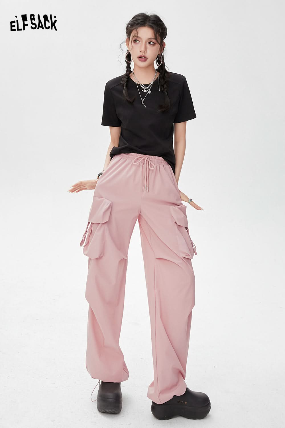 ELFSACK BM Style black T-shirt paired with pink cargo pants and black platform shoes