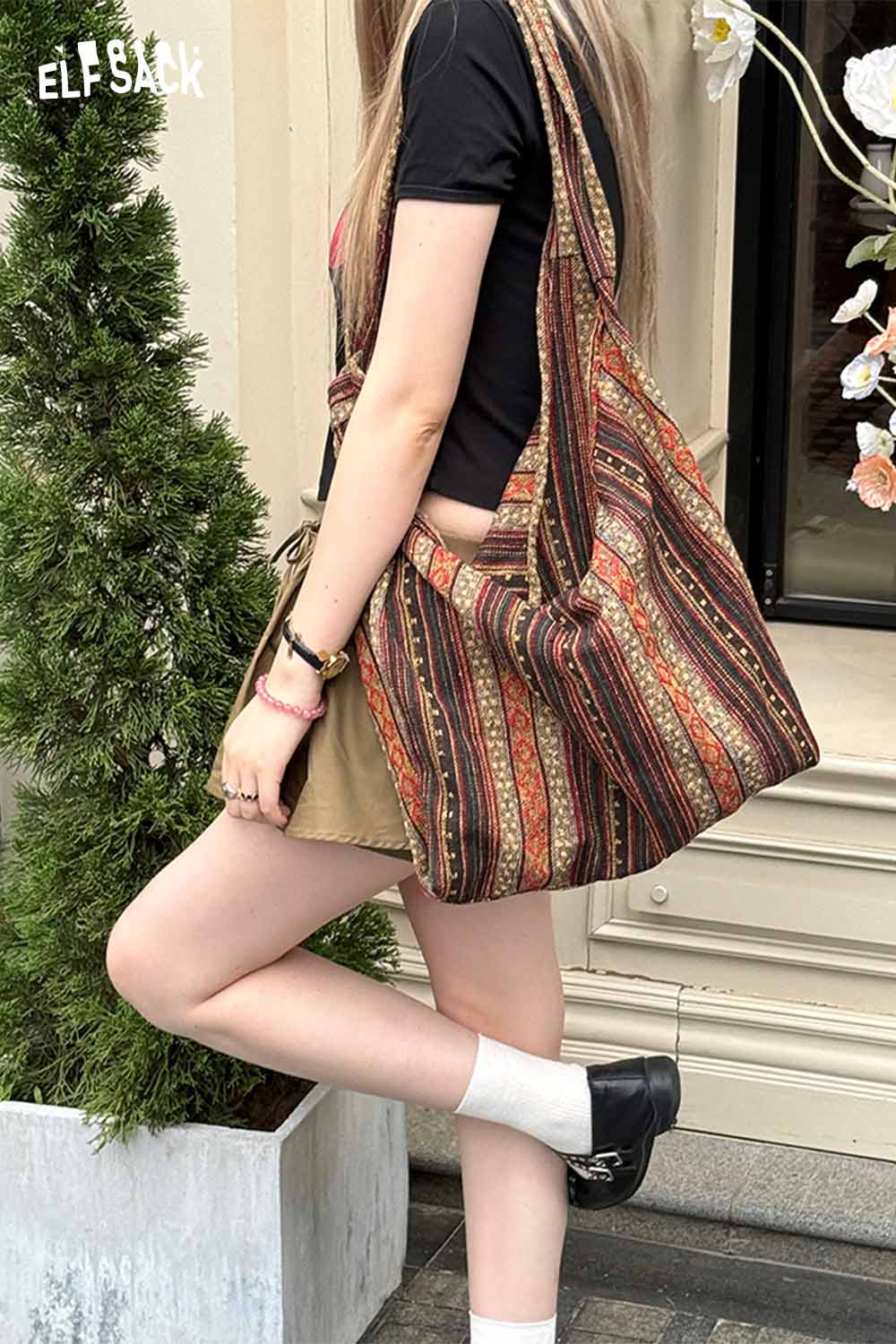 Stylish ELFSACK bohemian macrame tote bag displayed on a model, featuring a colorful pattern and comfortable shoulder strap
