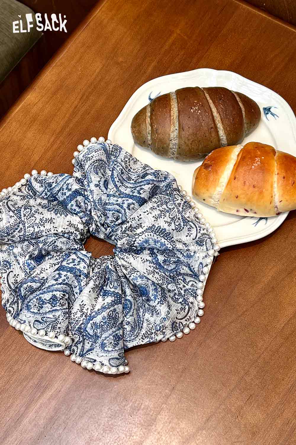 boho floral pearl hair band wide blue paisley scrunchie with pearl trim on wooden table next to bread