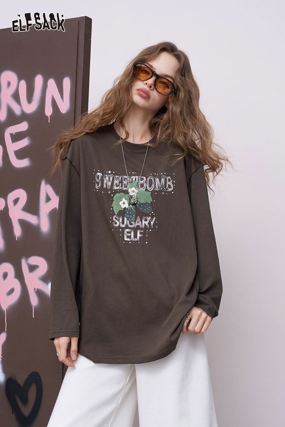 ELFSACK oversized daisy graphic tee for women long sleeve brown relaxed fit on model wearing sunglasses