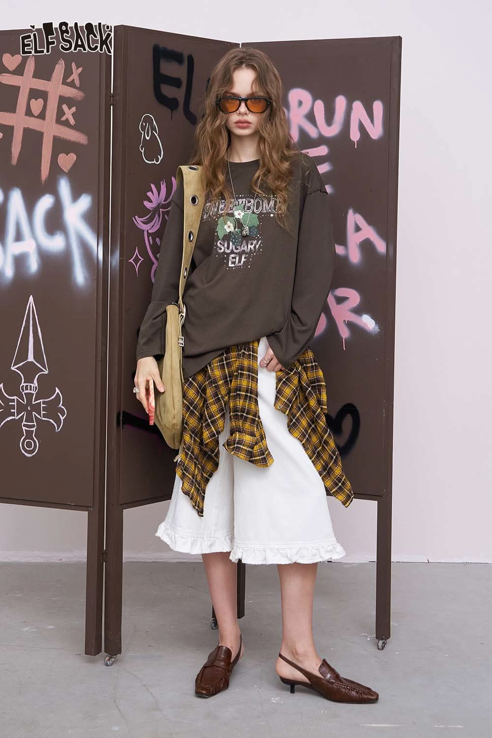 ELFSACK oversized daisy graphic tee for women styled with plaid shirt tied at waist white midi skirt ruffle hem