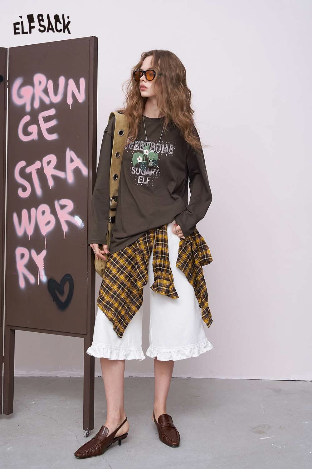 ELFSACK oversized daisy graphic tee for women in brown styled with yellow plaid tied at waist and white culottes