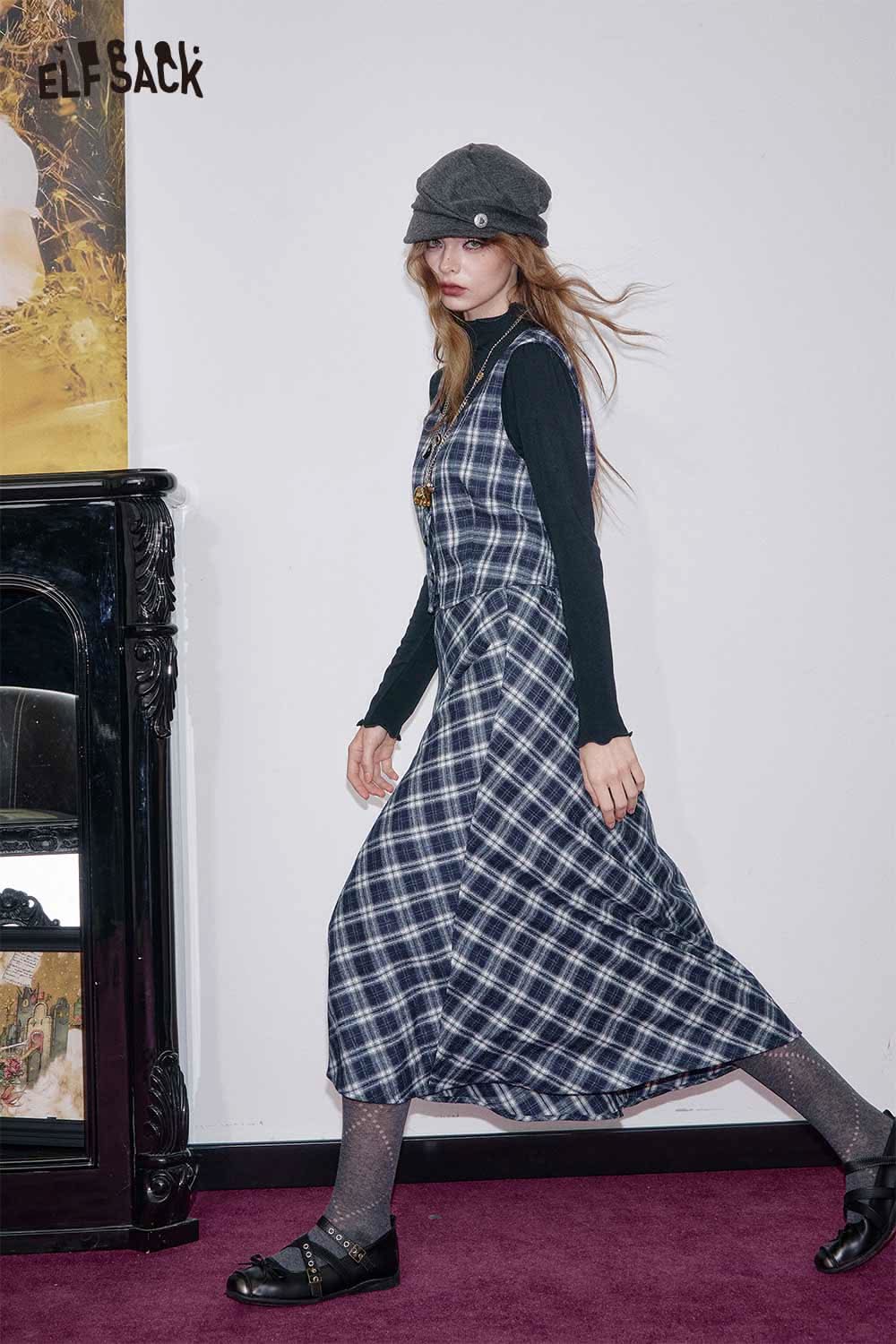 Model wearing a breathable plaid a-line skirt set from ELFSACK with a black long-sleeve top and stylish hat