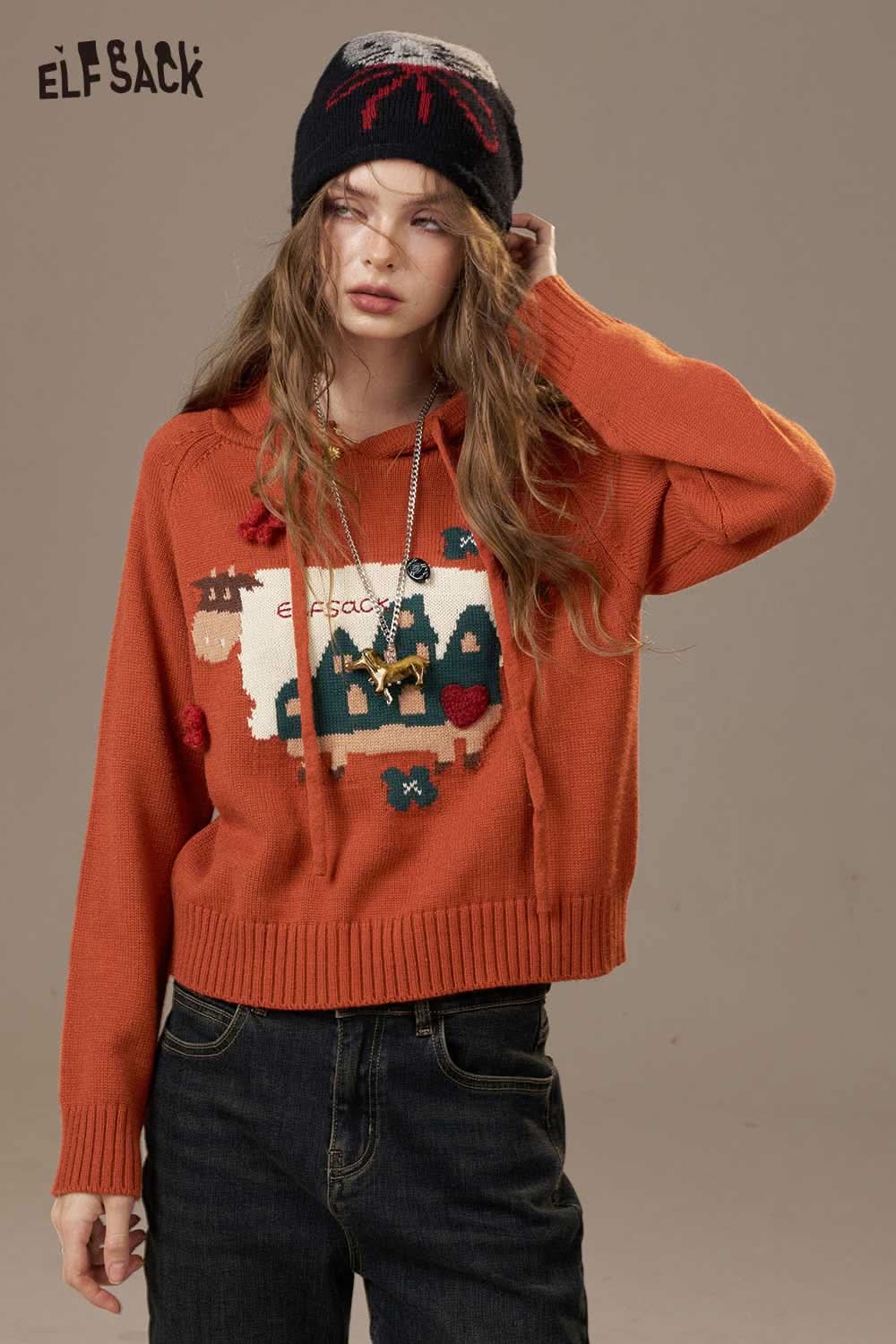 ELFSACK cartoon cow print hooded sweater in orange with playful designs and a relaxed fit