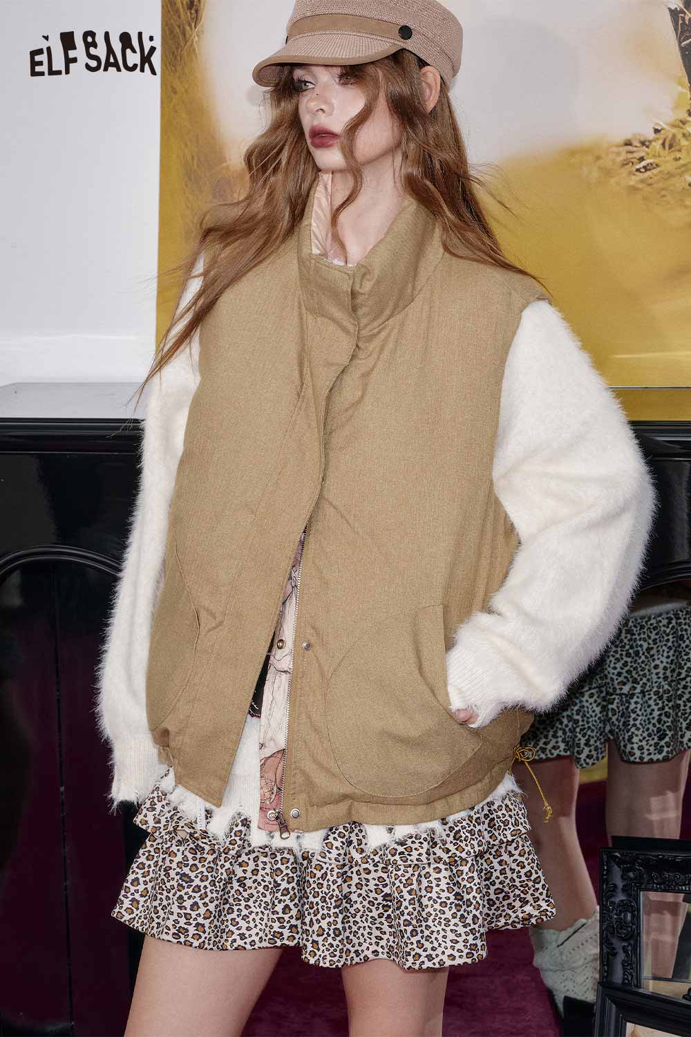 ELFSACK cartoon graphic puffer vest in beige with cozy white sleeves, styled with a leopard print dress