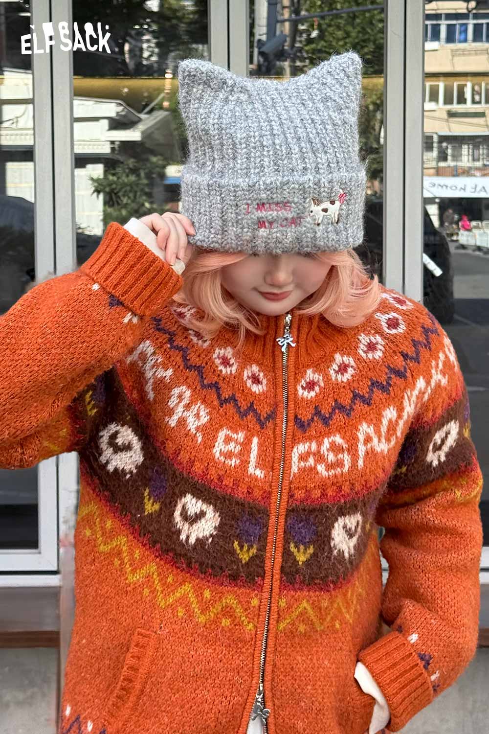 Cozy gray cat ear beanie for women styled with an orange patterned cardigan