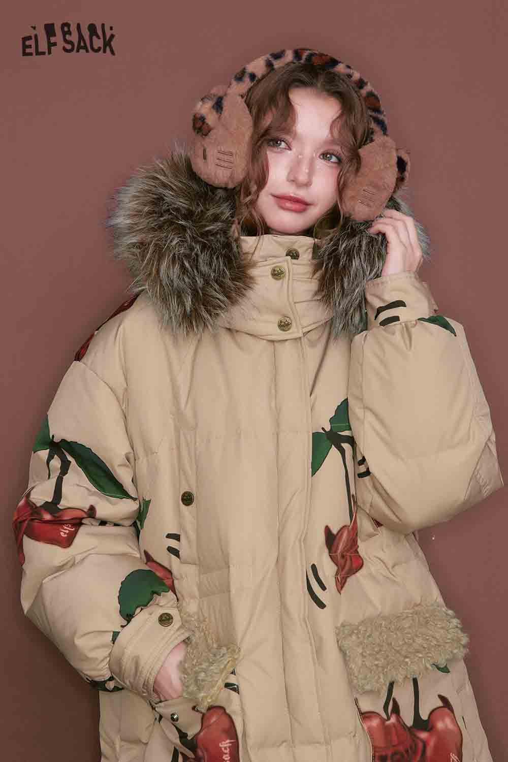 Model wearing a cherry graphic puffer coat with fur collar and playful cherry designs
