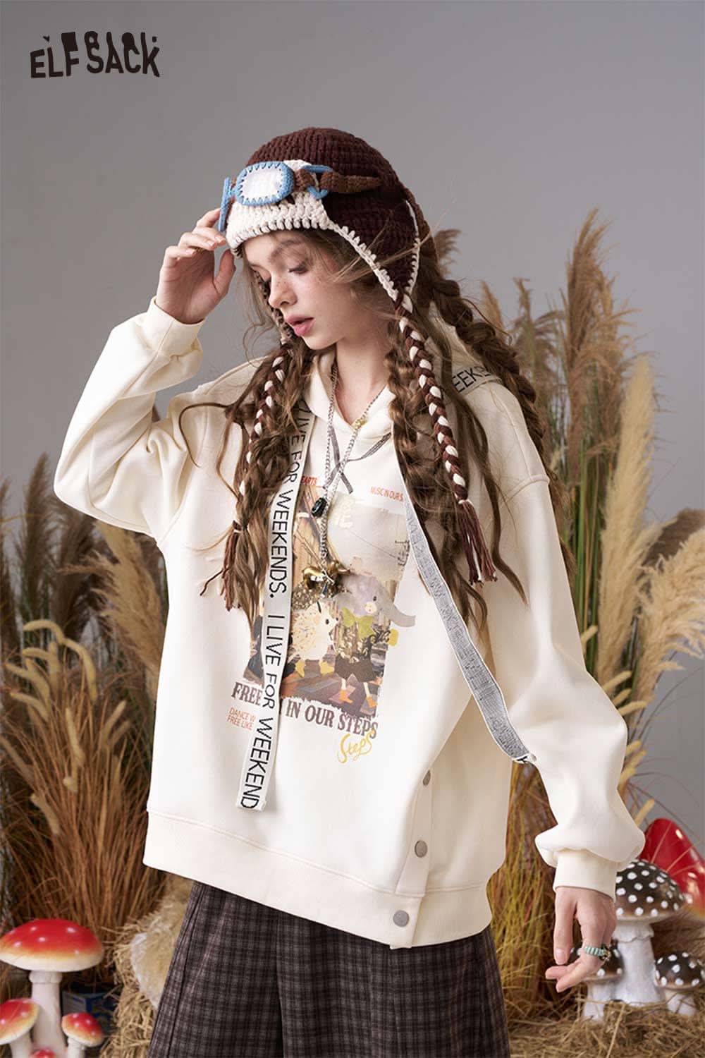 ELFSACK color blocked crocheted ear flap beanie worn with a graphic sweatshirt for a casual look