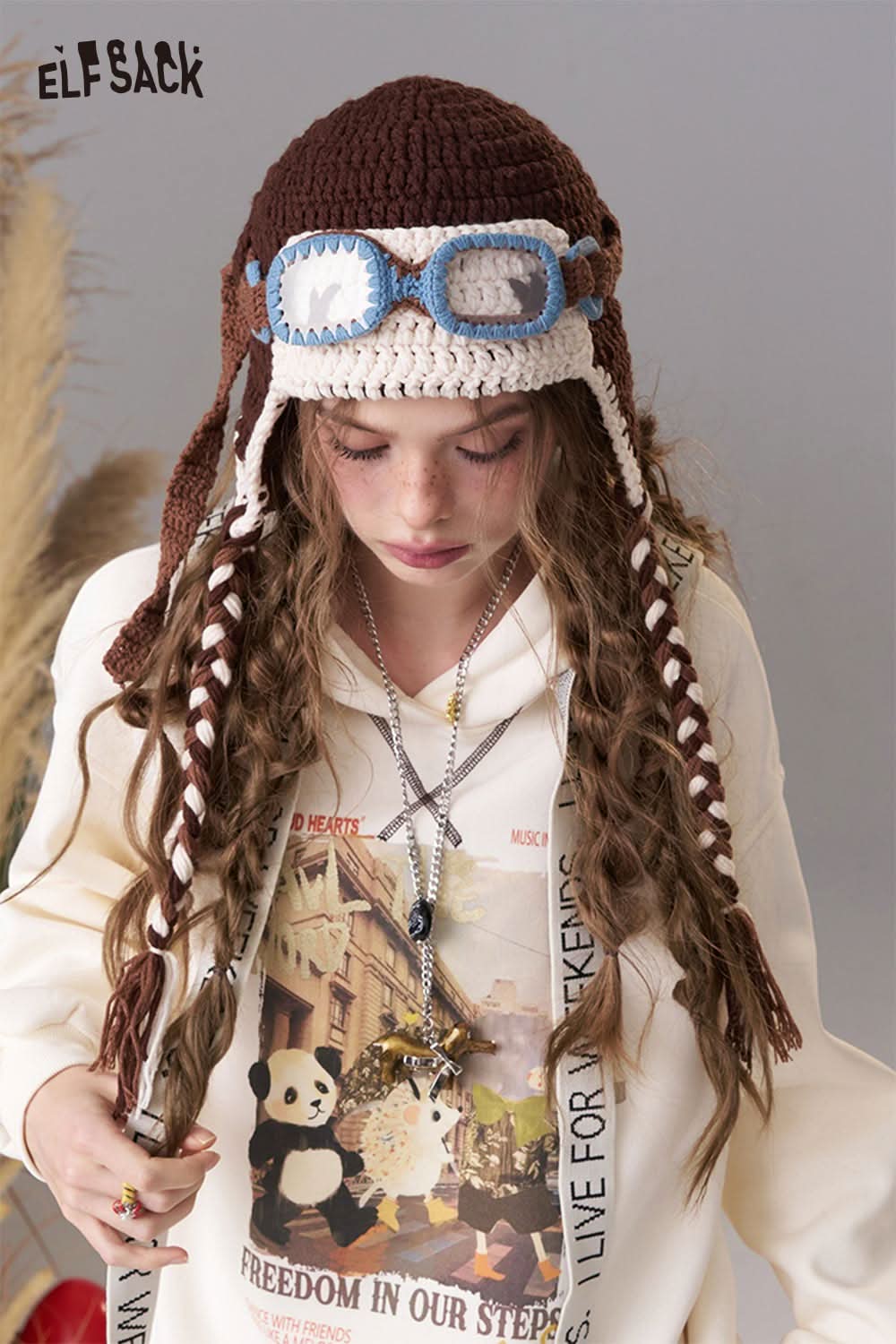 ELFSACK color blocked crocheted ear flap beanie with goggles and braids for a stylish and playful look