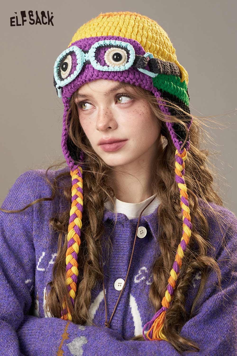 Color blocked crocheted ear flap beanie from ELFSACK with playful goggles and braided ties