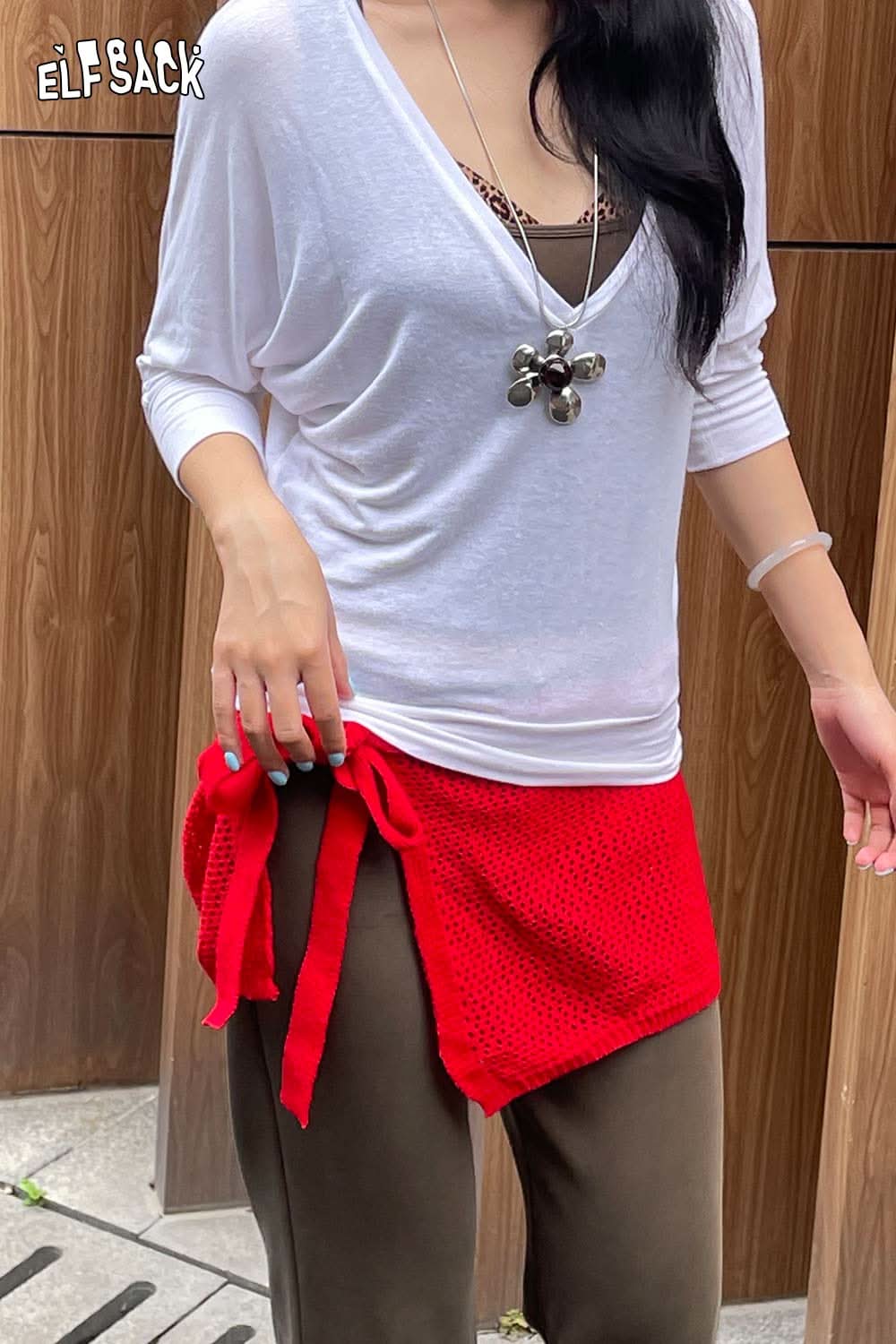 Casual outfit featuring a cotton blend knit skirt with apron in red, paired with a white top and stylish accessories