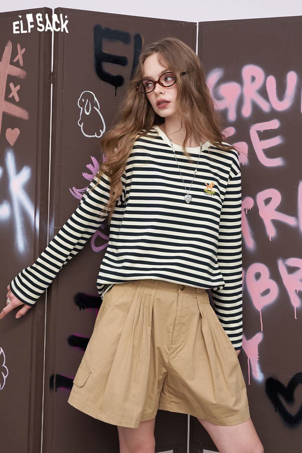 ELFSACK model wearing cotton striped long sleeve tee black cream with tan shorts casual street style