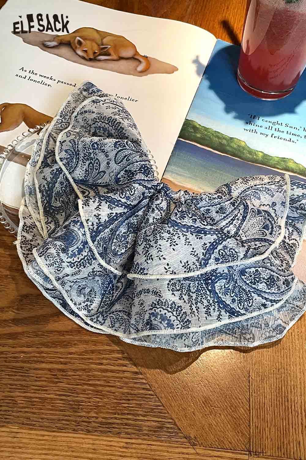 ELFSACK bohemian paisley hair tie blue white ruffled scrunchie on wooden table with book and drink