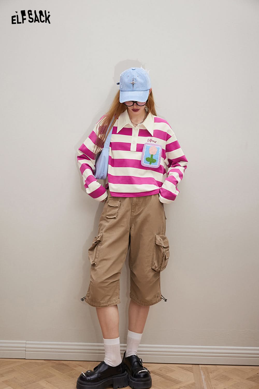 ELFSACK striped T-shirt with Croche Flower Striped patch detail worn with cargo shorts and a blue cap