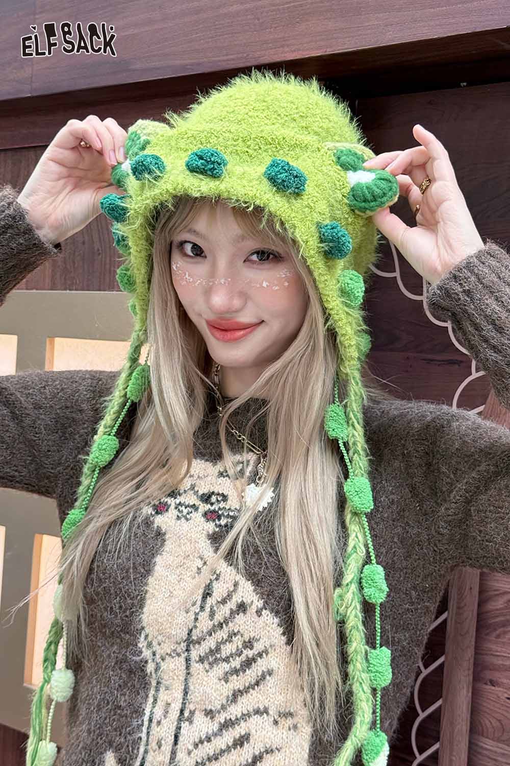 Woman wearing a cute 3D ear beanie hat with colorful pom-poms and a cozy sweater