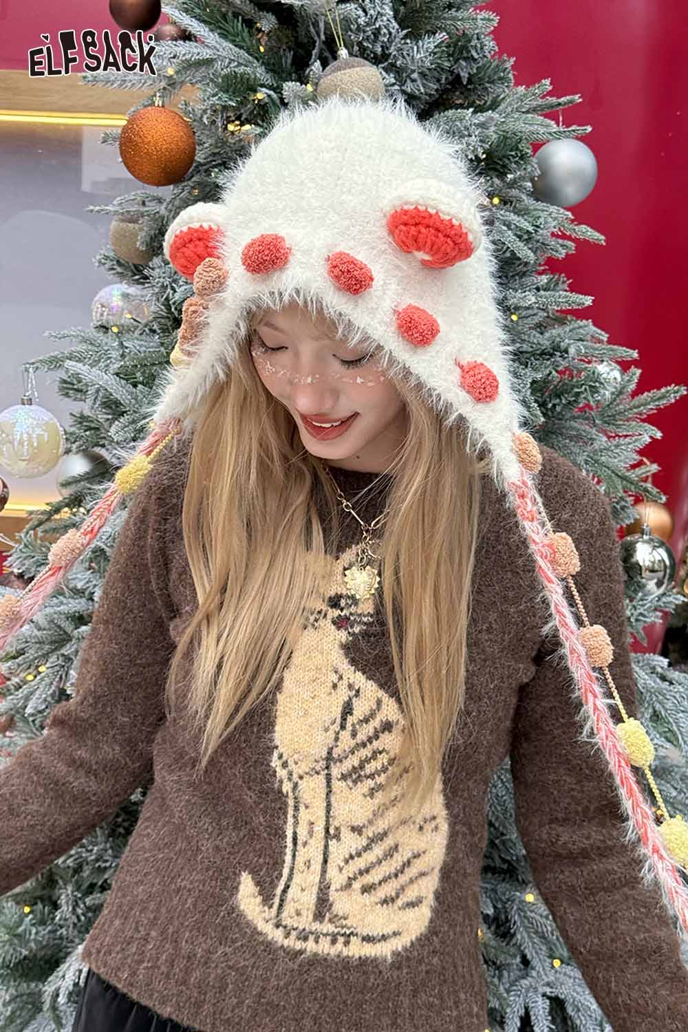 Cute 3D ear beanie hat from ELFSACK with colorful pom poms and ear flaps for a playful winter look