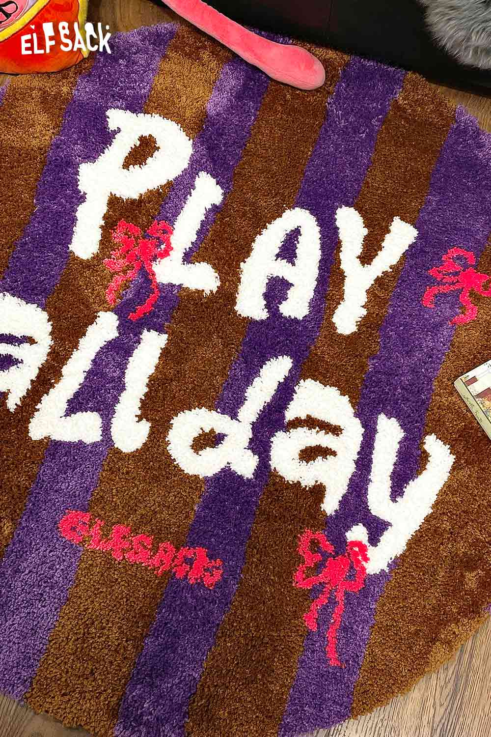 Cute round striped rug in brown and purple with the text Play All Day for a playful home decor