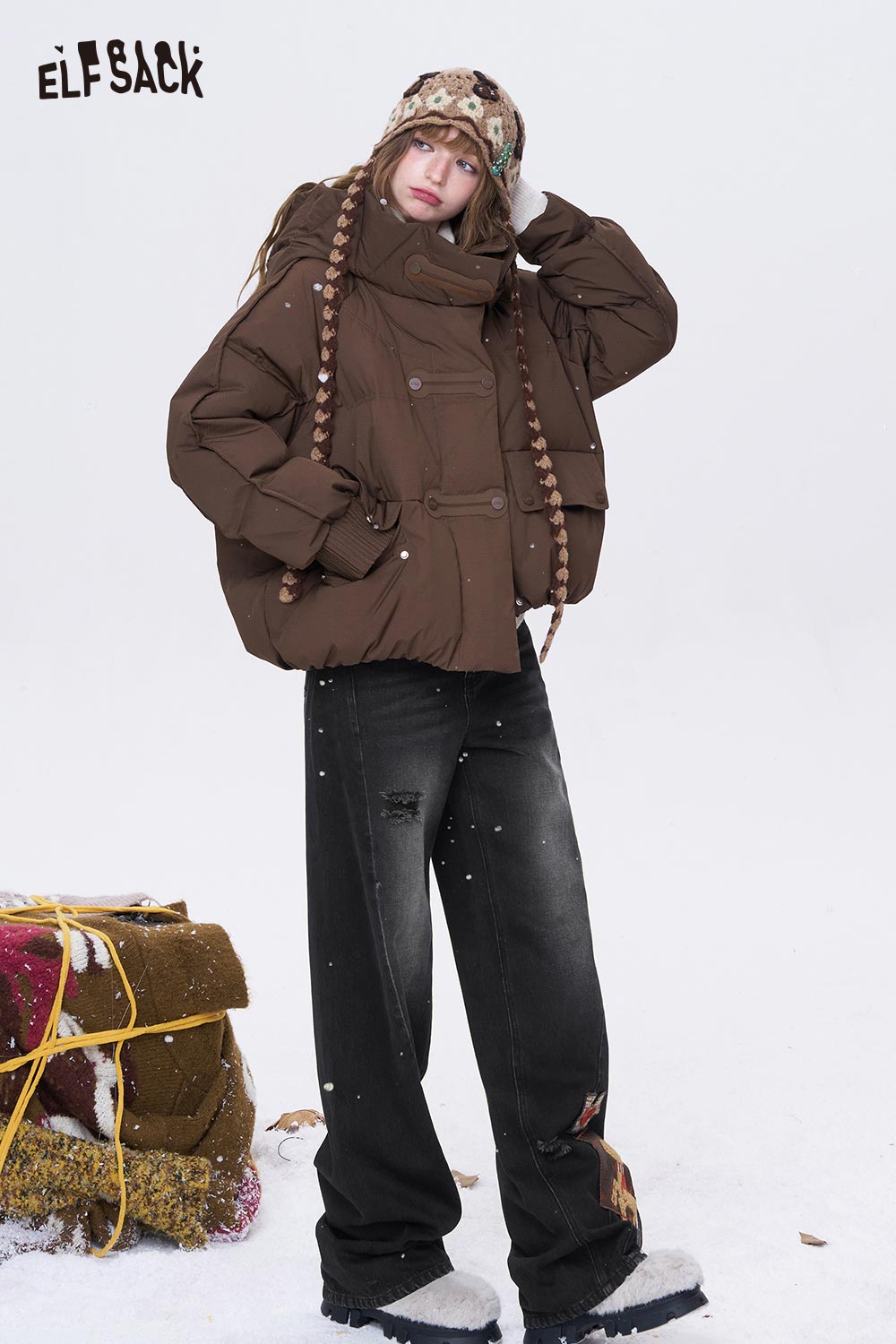 ELFSACK deer patchwork wide leg jeans styled with a brown puffer jacket in a snowy outdoor setting