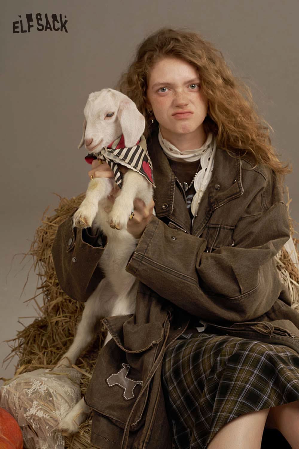 ELFSACK women's loose denim jacket styled with a model holding a goat in a rustic setting