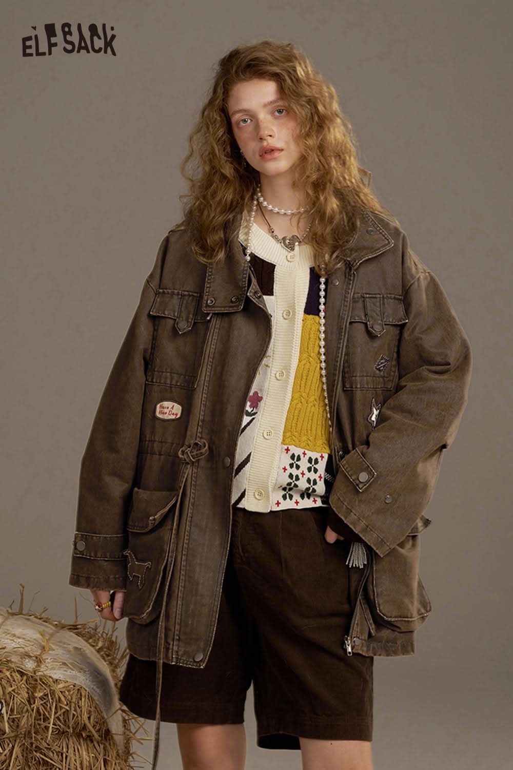 ELFSACK women's loose denim jacket styled with a colorful knitted sweater and brown shorts