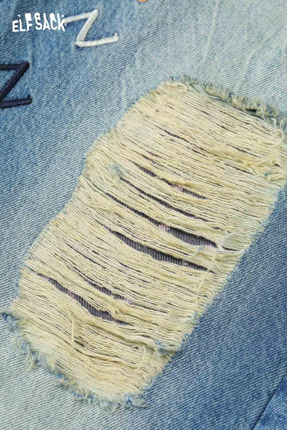 Close-up of ELFSACK dog graphic distressed jeans showcasing detailed ripped fabric texture