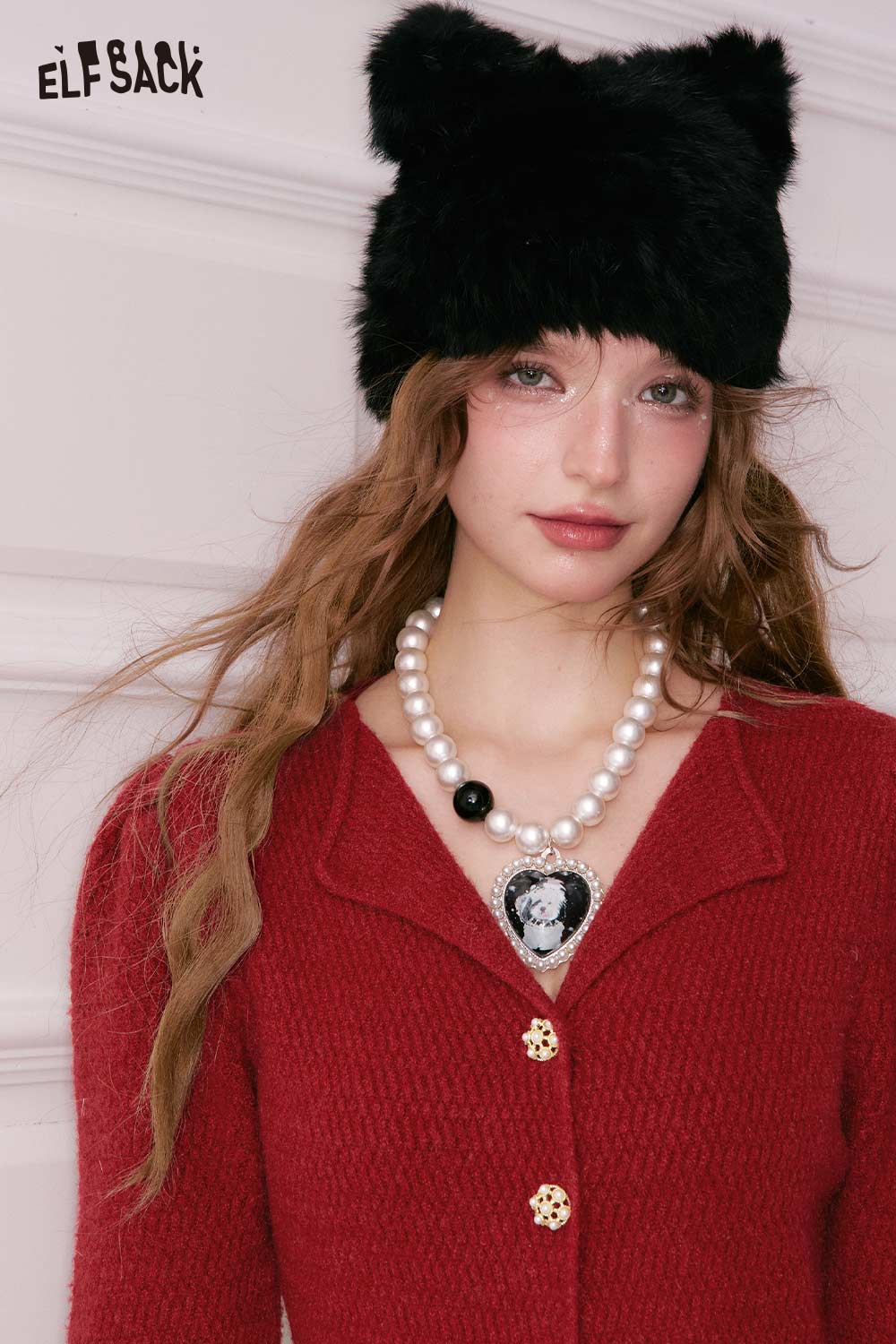 Model wearing a vibrant red ELFSACK elegant gold button dress with a stylish black hat and pearl necklace