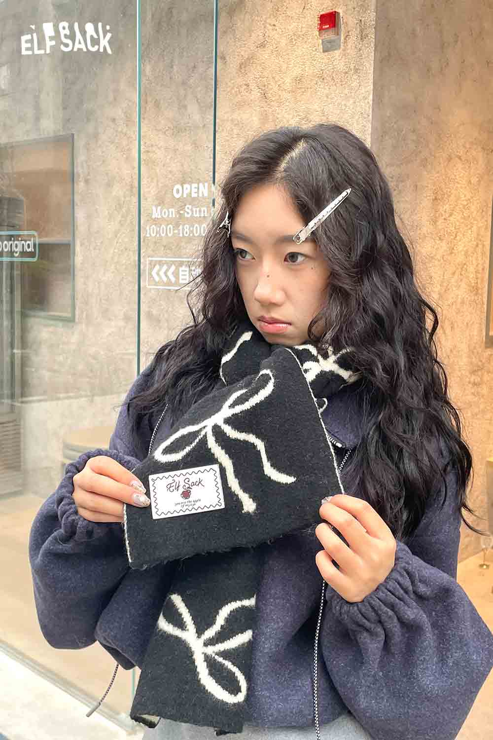 ELFSACK bow graphic neck warmer in black featuring a stylish bow design for trendy winter fashion