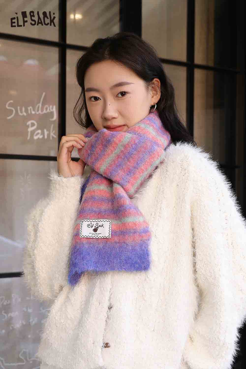 ELFSACK Christmas striped scarf for women in pink and blue, worn with a cozy white sweater