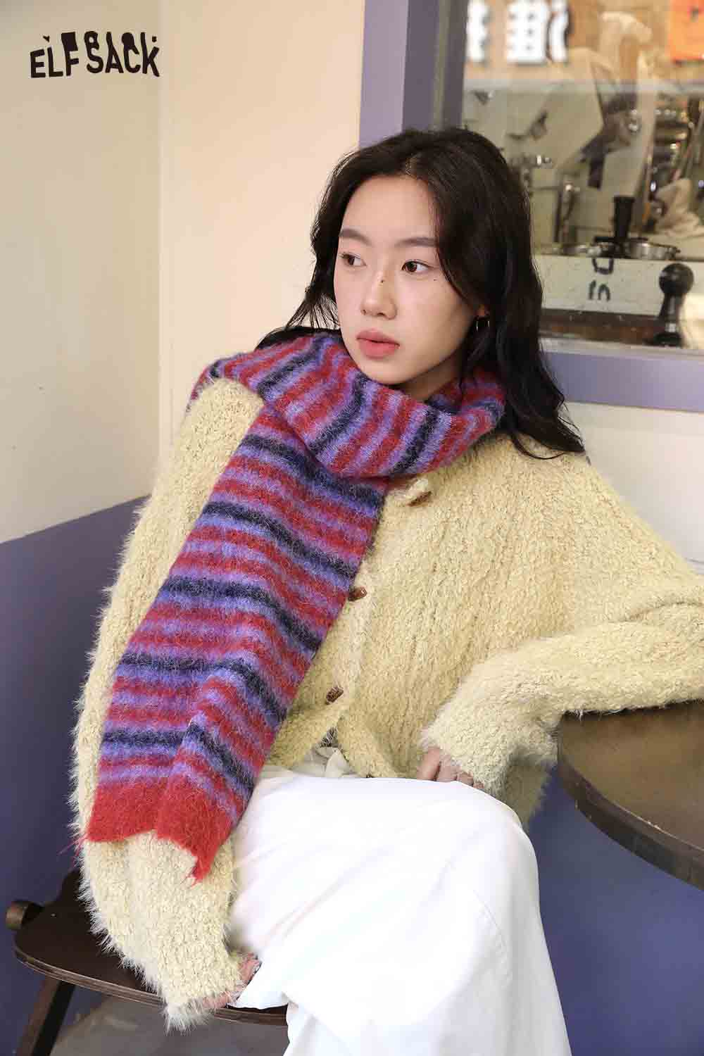 Cozy Christmas striped scarf for women in vibrant red and blue, styled with a fluffy sweater