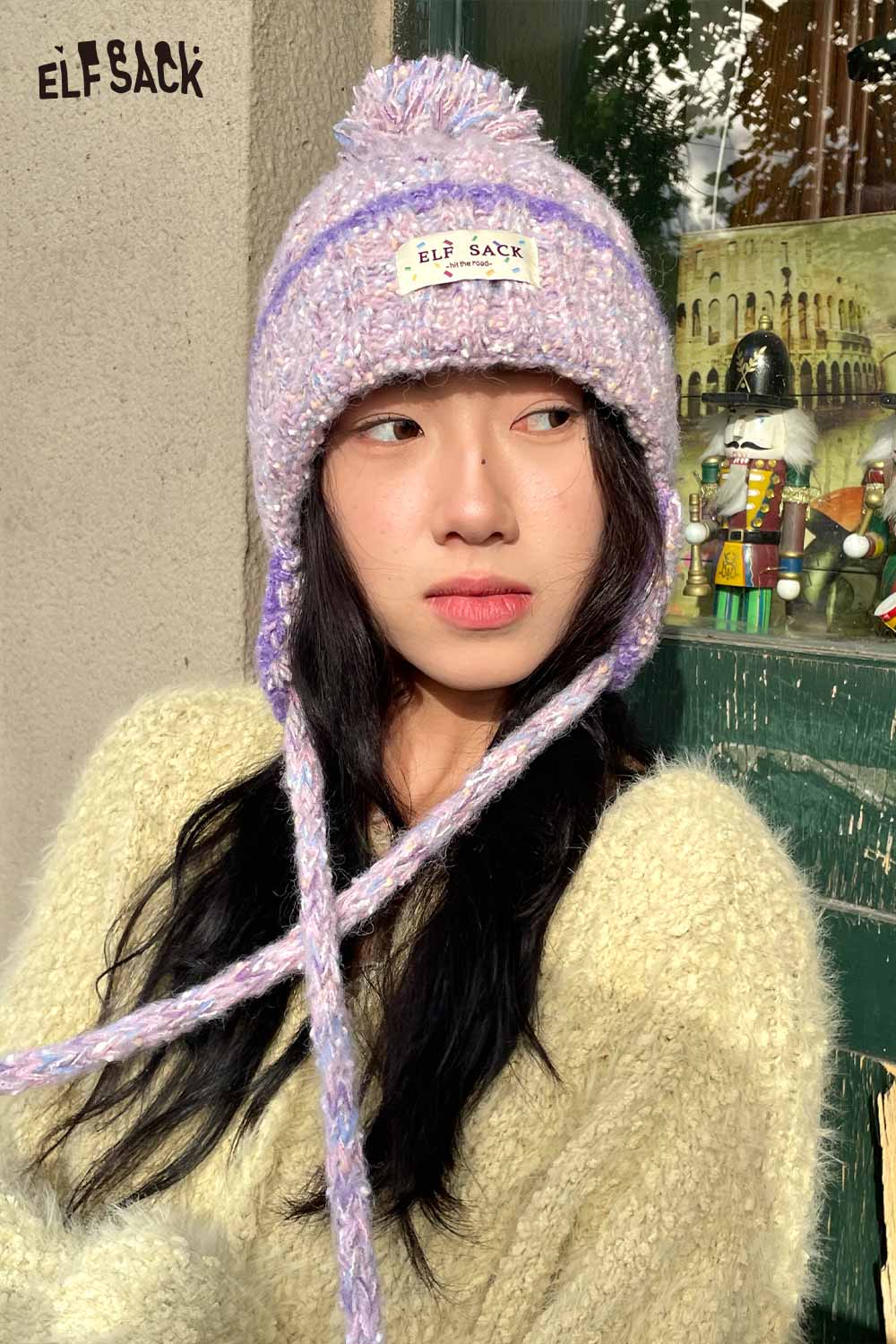 ELFSACK cute striped pom beanie for women in pastel colors with braided ties and a soft knit design