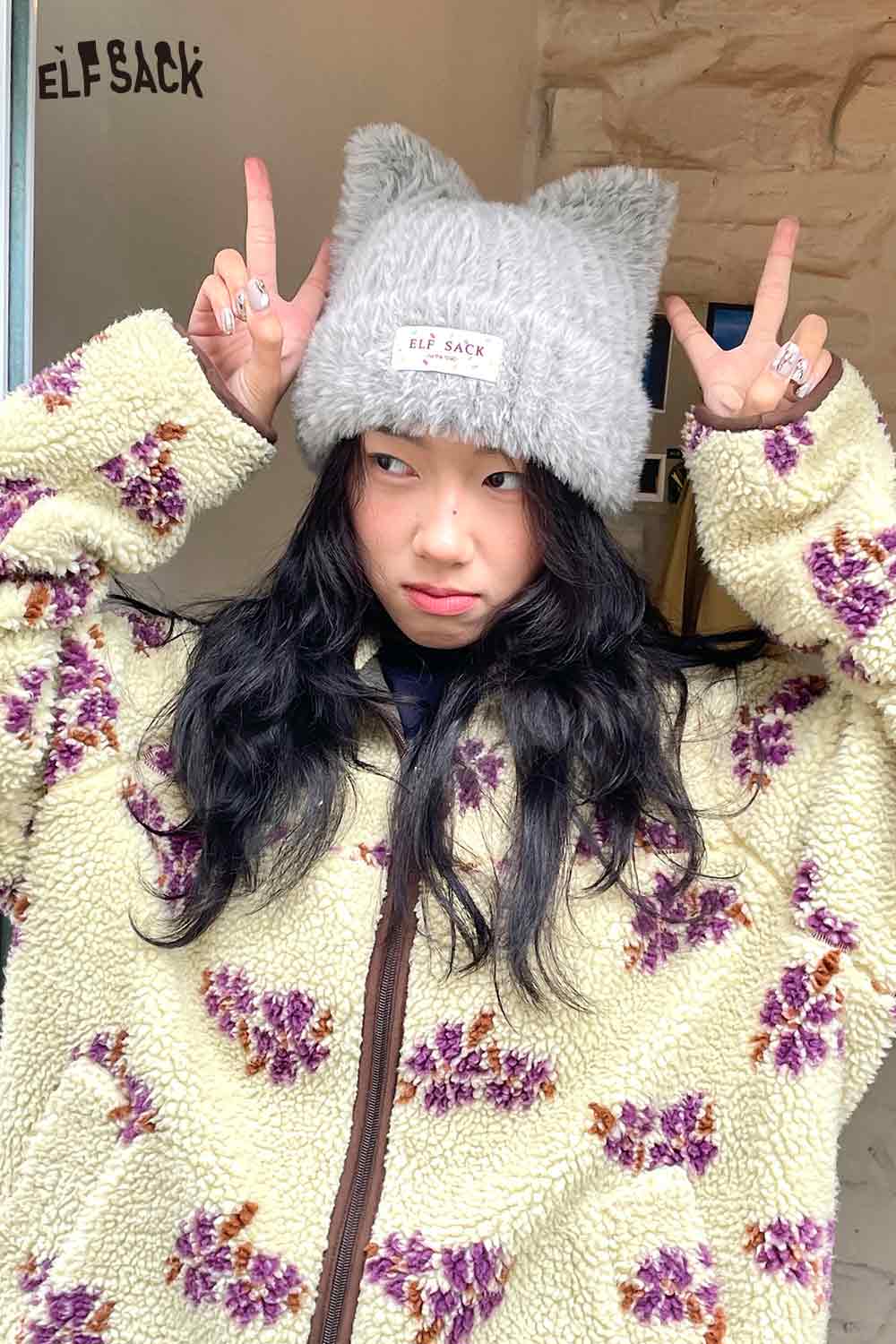 Cozy ELFSACK plush cat ear hat for women modeled with a floral fleece jacket
