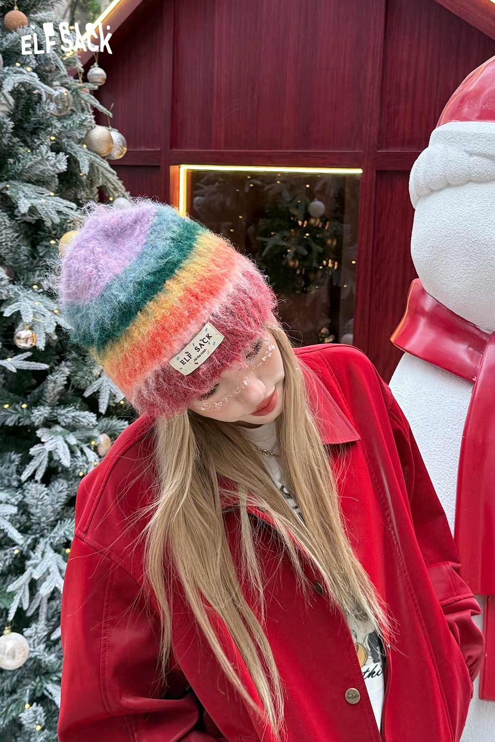 ELFSACK rainbow striped knit beanie in pastel colors worn by a model outdoors