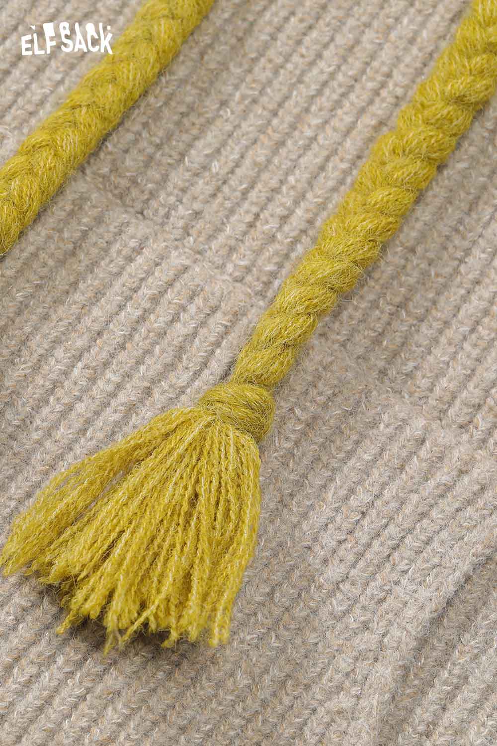 Close-up of braided tassels on ELFSACK color block hooded dress in soft fabric design