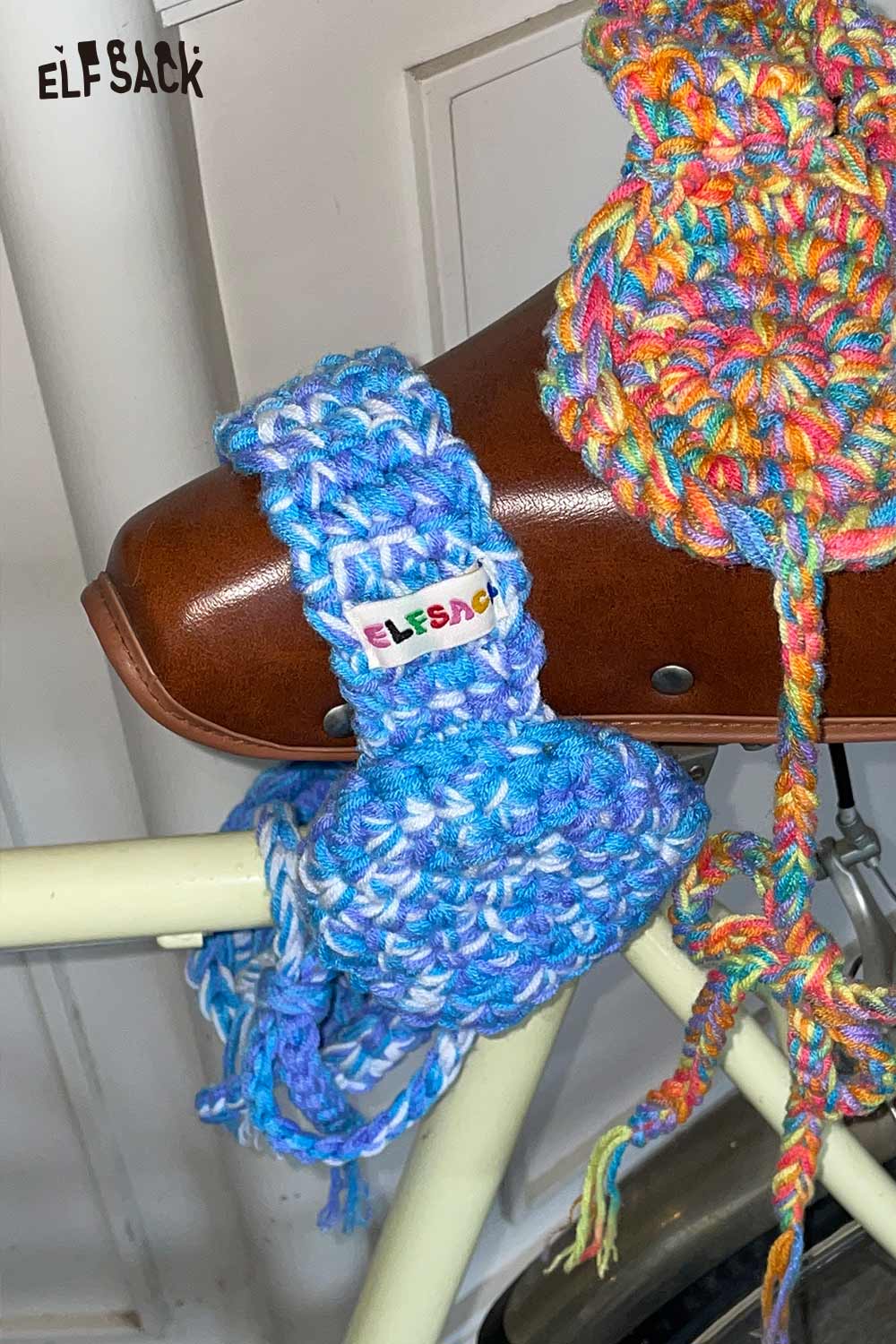 ELFSACK hand-knitted ear warmers in vibrant blue tones displayed on a bicycle for cozy winter fashion