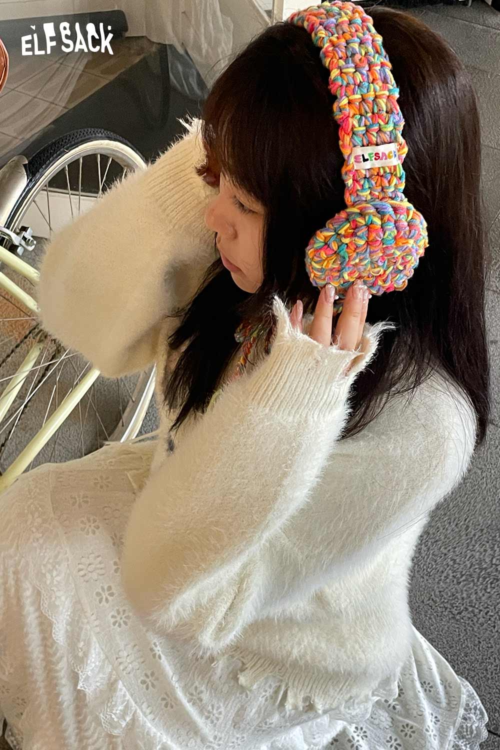 Colorful ELFSACK hand-knitted ear warmers worn by a girl in a cozy sweater