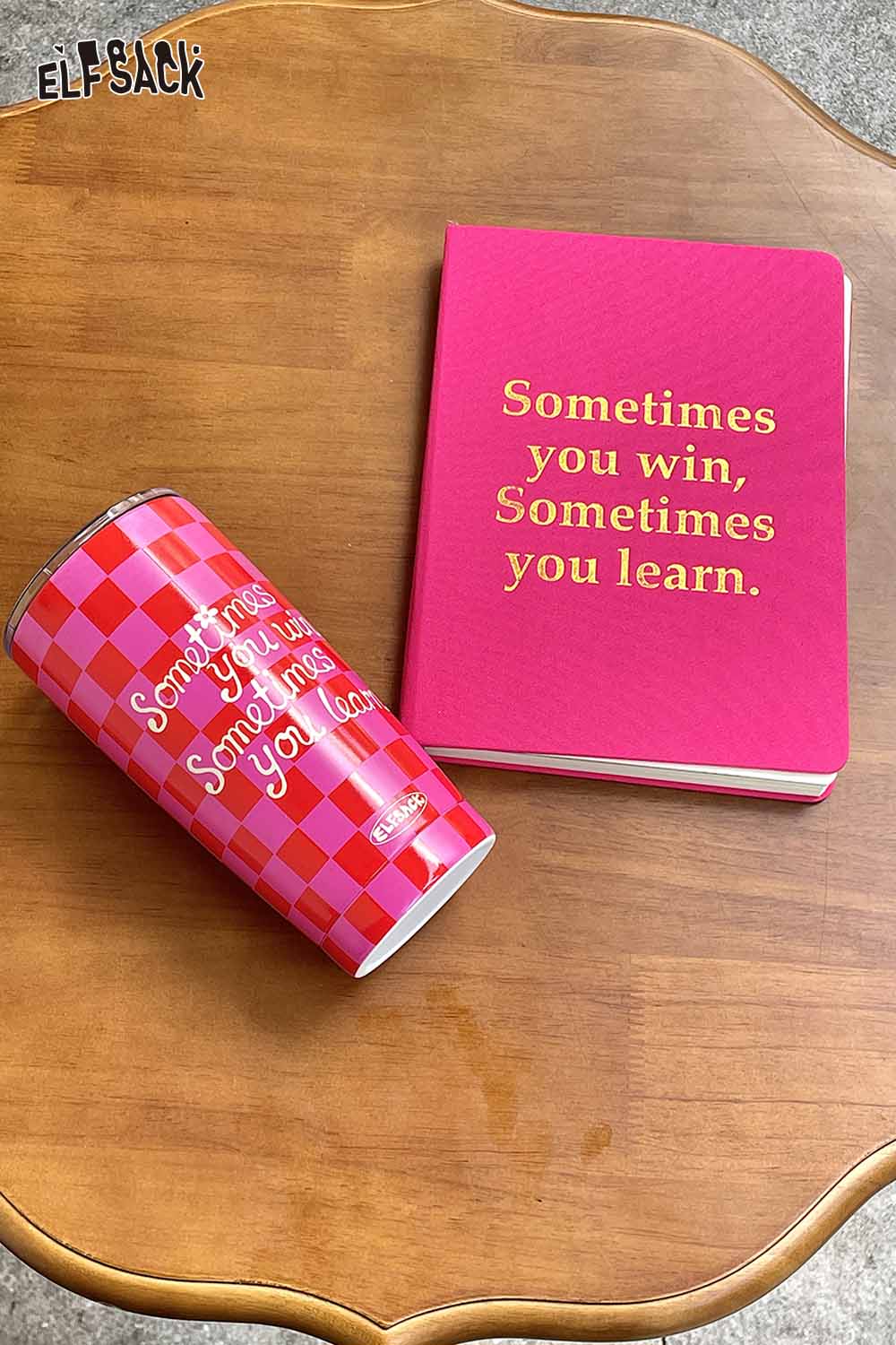 ELFSACK plaid stainless steel tumbler next to a pink notebook with a motivational quote