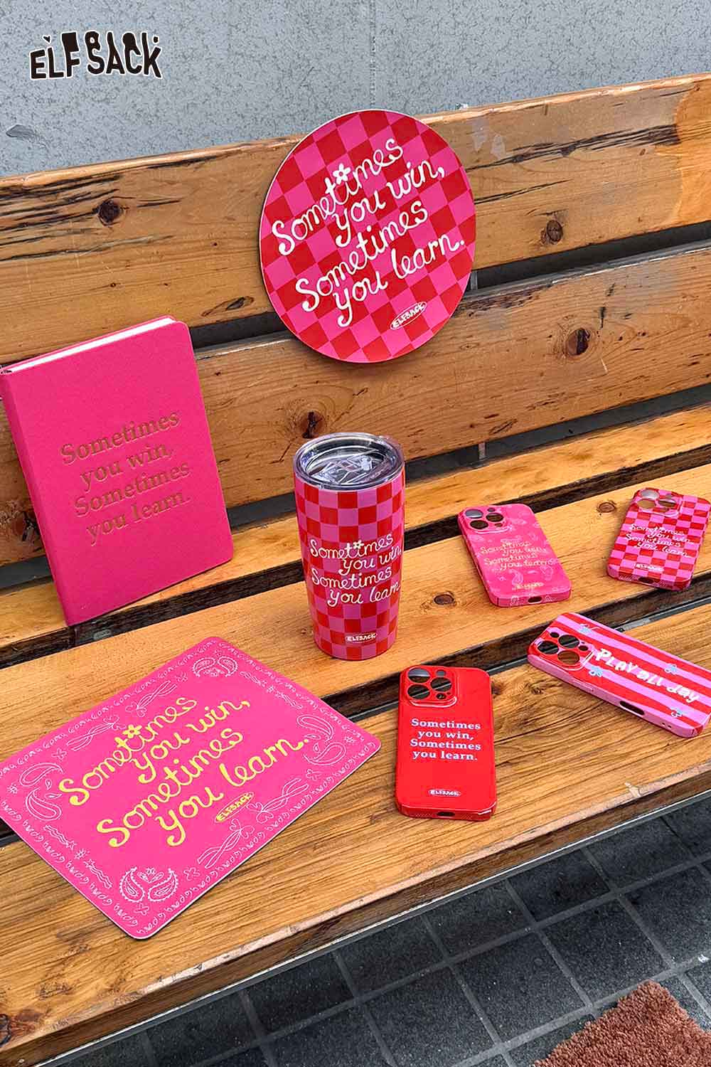 ELFSACK plaid stainless steel tumbler displayed on a wooden bench with motivational accessories