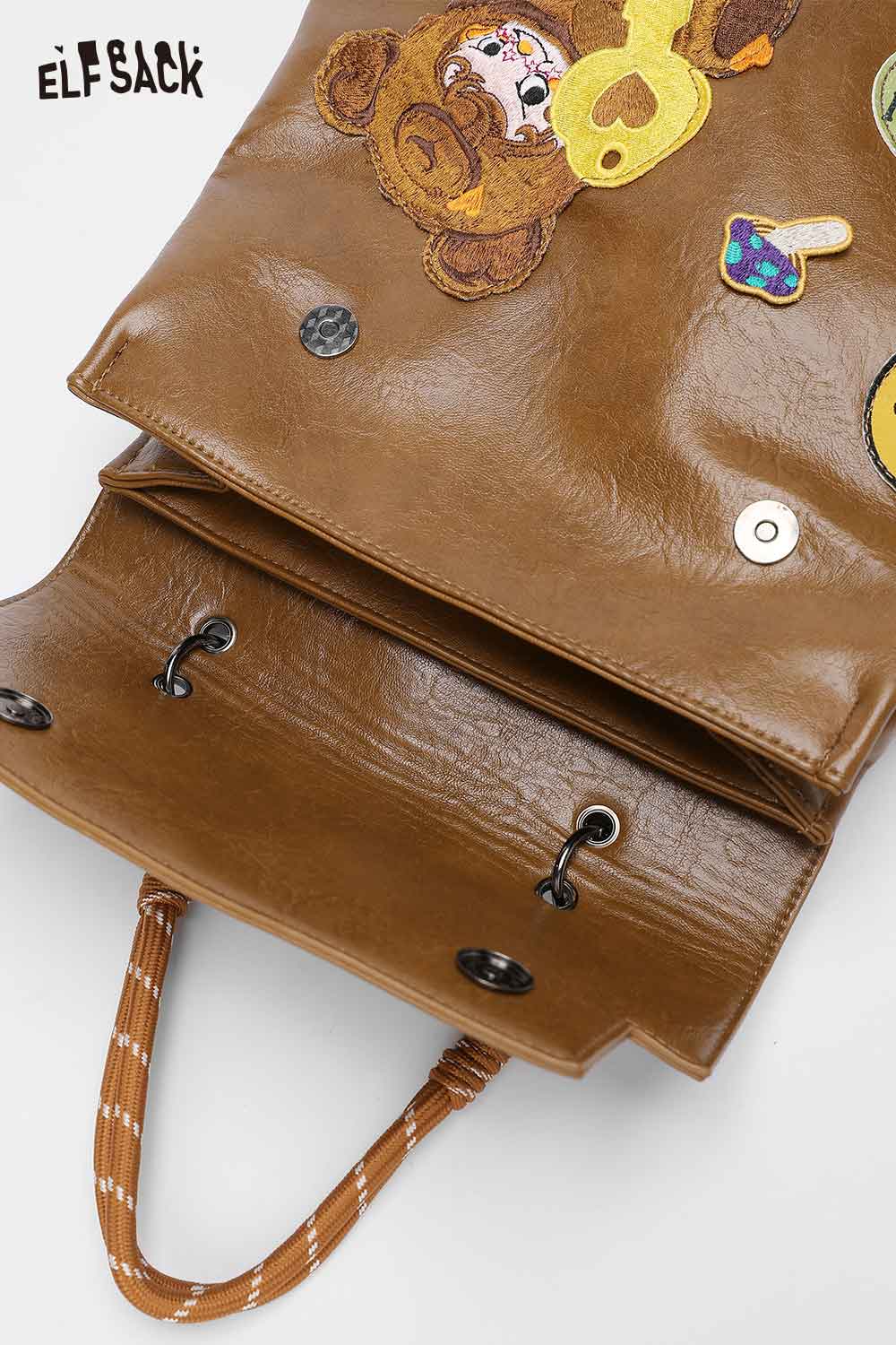 Open ELFSACK playful embroidery PU leather backpack showcasing colorful designs and spacious interior