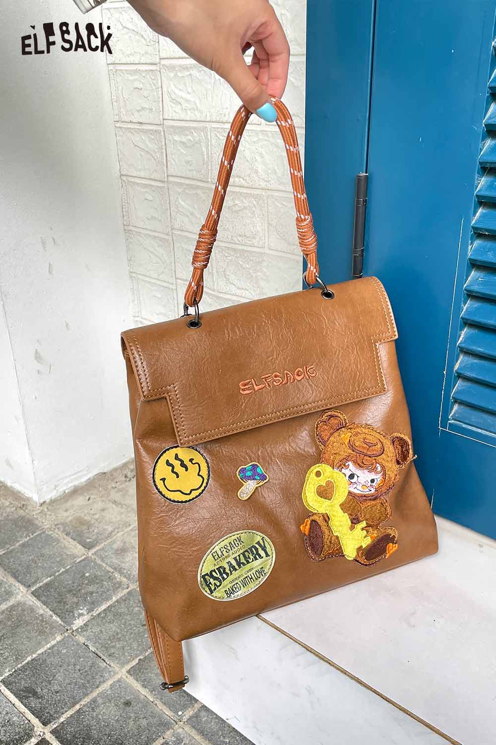 ELFSACK playful embroidery PU leather backpack in brown with cute patches and a braided handle